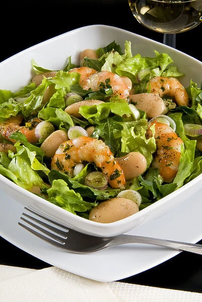 Salad with shrimp, white beans, onions and arugula with balsamic vinegar