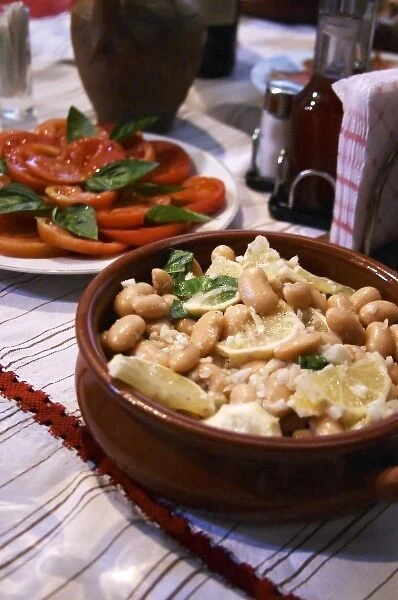 Salad with white beans in an earthenware bowl. Tomato and basil salad. White beans