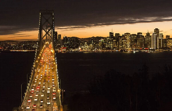 San Francisco California skyline and the Oakland Bay Bridge at evening with traffic on bridge