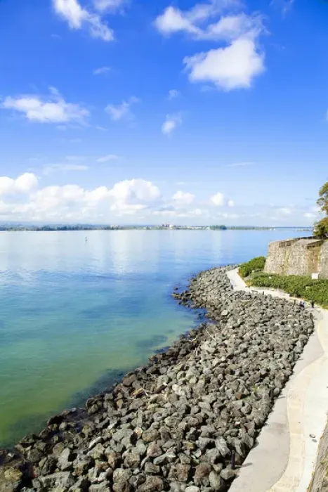 Framed Print : San Juan, Puerto Rico - A sidewalk passes above a rocky beach of calm water. Vertical Framed Print : San Juan, Puerto Rico - A sidewalk passes above a rocky beach of calm water. Vertical