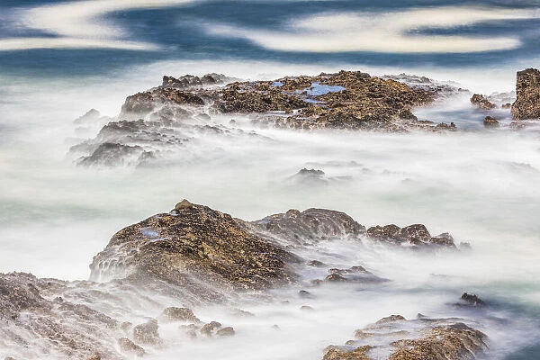 Shore Acres State Park, Oregon, USA. Blur of waves flowing over rocks