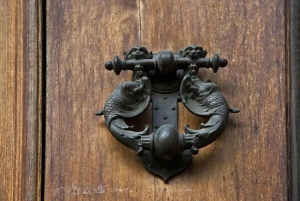 Sienna, Tuscany, Italy - Closeup of ornate, metal door knocker on a wooden door