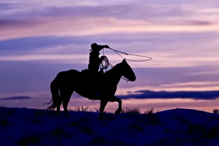 Framed Print : A silhouette of a cowboy on horses with the winter sky on The Hideout Ranch in Shell Wyoming