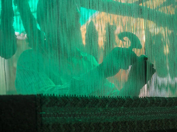 Silhouette of man operating handloom machine in Jaipur, Rajasthan, India
