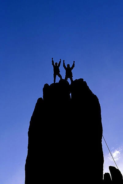 Silhouetted climbers celebrating on the summit of Eichorn Pinnacle, Yosemite National Park