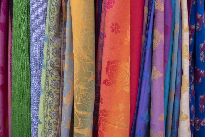 Framed Print : Singapore, Chinatown. Detail of typical textile souvenir scarves