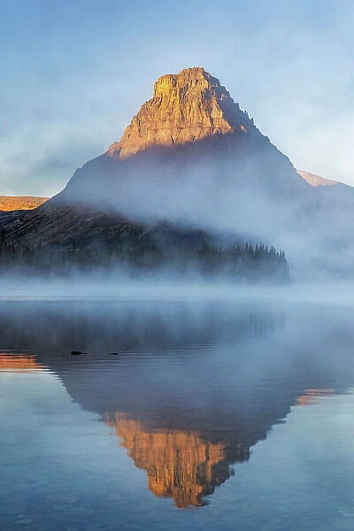 Sinopah Mountain and foggy sunrise over Two Medicine Lake in Glacier National Park, Montana, USA