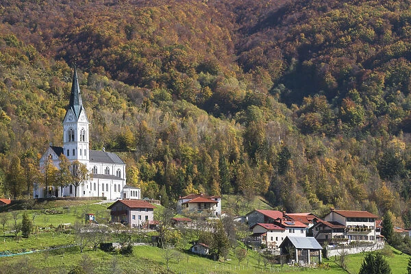 Slovenia, Dreznica. Parish Church of the Sacred Heart towers above the village, surrounded