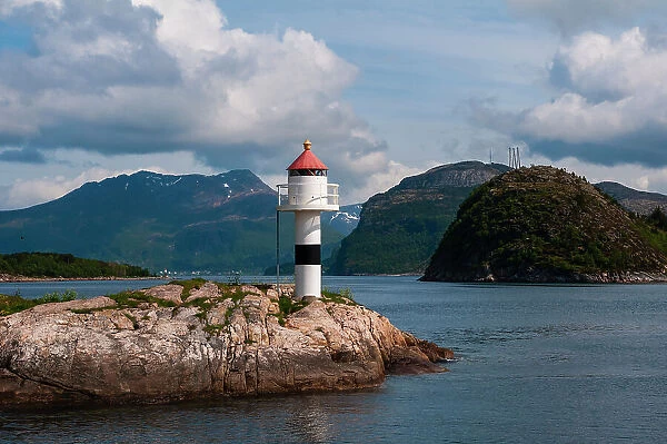 A small lighthouse perched on a rock promontory in Hollandsfjord, Svartisen, Norway