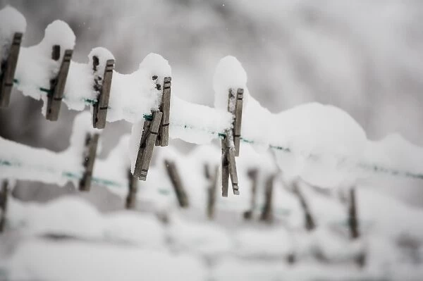 Snow on clothes pins on a clothes line