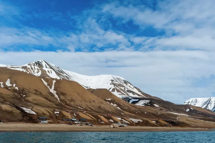 Framed Print : Snow streaked cliffs rise behind a small settlement near Longyearbyen on the bay of Adventfjorden. Spitsbergen Island, Svalbard, Norway Framed Print : Snow streaked cliffs rise behind a small settlement near Longyearbyen on the bay of Adventfjorden. Spitsbergen Island, Svalbard, Norway
