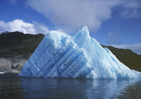 South America, Chile, San Rafael Lagoon NP. A striated, sun-touched iceberg floats