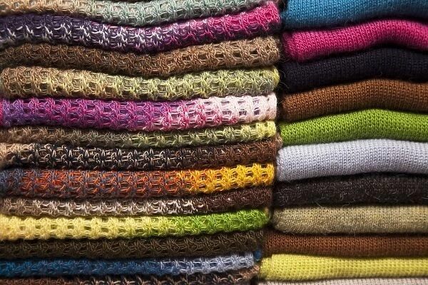South America, Peru, Aguas Calientes. Stack of colorful textiles made of alpaca wool