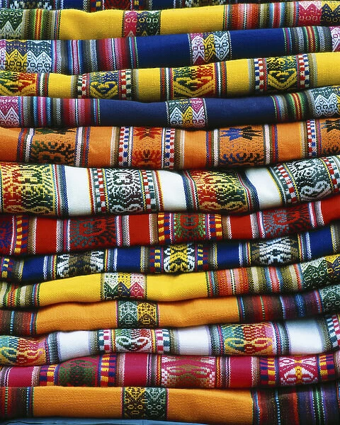 South America, Peru, near Cusco. Stack of colorful blankets for sale in market. Credit as