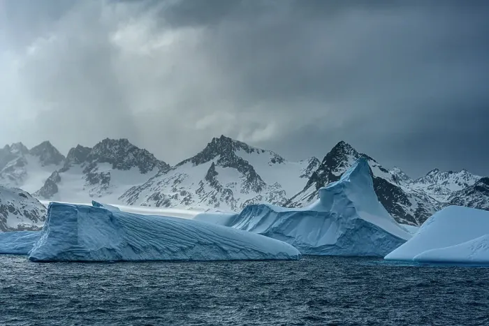 Framed Print : South Georgia Island. Sculpted blue icebergs floating in the Atlantic and mountain scenery