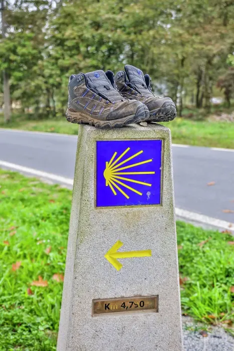 Framed Print : Spain, Galicia. Distance marker on the Camino de Santiago (Way of St. James) with a pair of well worn shoes. (Editorial Use Only)