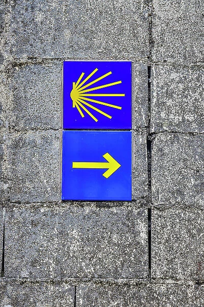Spain, Galicia. Yellow arrow and clam shell along the Camino de Santiago (Way of St. James) between Lavacolla and Santiago de Compostela