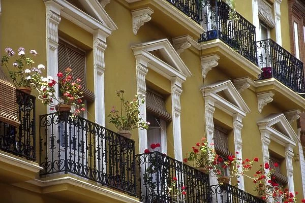 Spain, Sevilla, Andalucia Geraniums hang over iron balconies of traditional houses