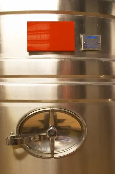 Framed Print : A detail of a stainless steel wine fermentation tank with the opening. The winery is designed