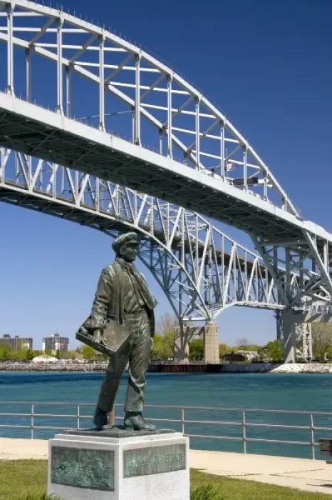 Framed Print : A statue of Thomas Edison by local artist Mino Duffy sits below the Blue Water Bridge along the St