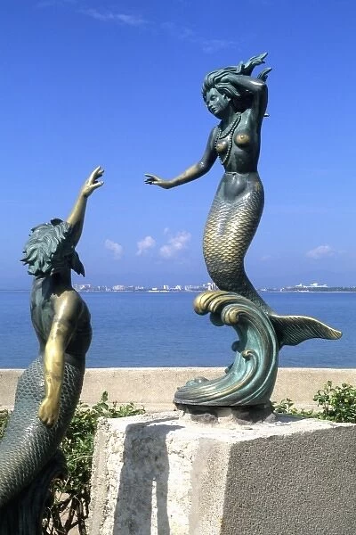 Statues of bronze mermaids on the beach in Puerto Vallarta Mexico