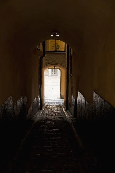 Stockholm, Sweden - Image of a dark, enclosed walkway. Sunlight can be seen from the arched exit