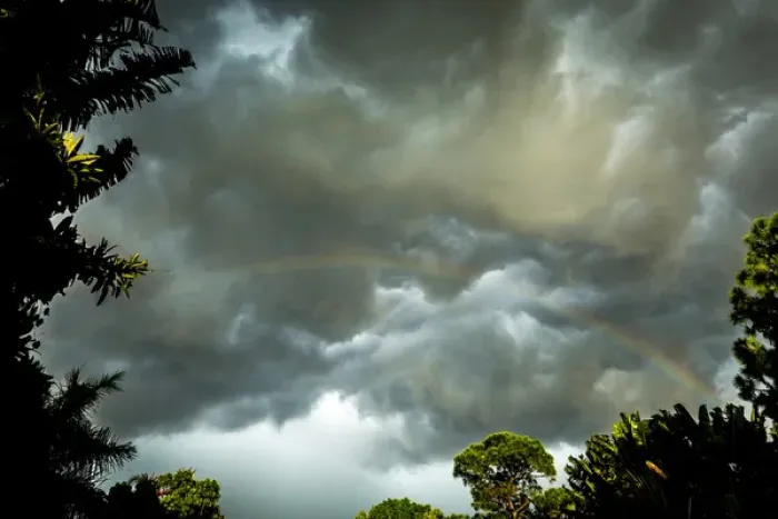 Framed Print : Storm clouds approach in this photograph while a rainbow is illuminated by sunrays Framed Print : Storm clouds approach in this photograph while a rainbow is illuminated by sunrays