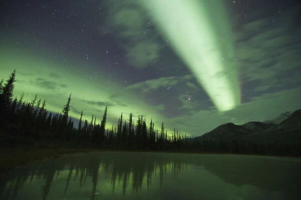 Streamers of bright green aurora borealis fill the north sky over the Brooks Range