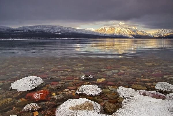 Sun breaks through the clouds at Lake McDonald on a winter evening in Glacier National