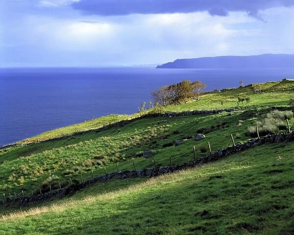 The sun lights the verdant headlands of Antrim Coast, Northern Ireland