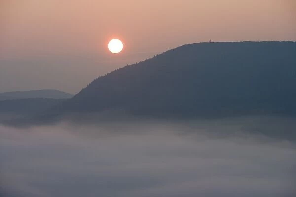 The sun rises above fog on the Connecticut River as seen from South Sugarloaf Mountain