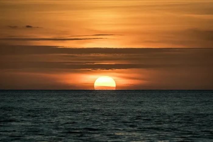 Framed Print : Sun sets amid light clouds in the Gulf of Mexico
