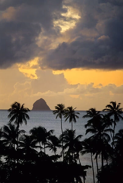 The sun sets behind Diamond Rock viewed from the island of Martinique in the Caribbean