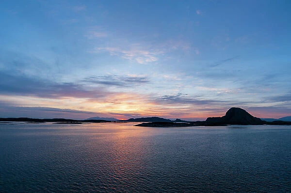 The sun sets beyond silhouetted islands in the Norwegian Sea near Bronnoysund. Norwegian Sea near Bronnoysund, Bronnoy, Norway