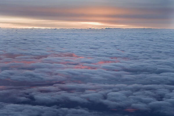 Sunrise from an airliner looking down at clouds