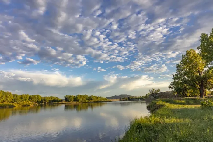 Framed Print : Sunrise and clouds over the Powder River near the confluence with the Yellowstone River near Terry