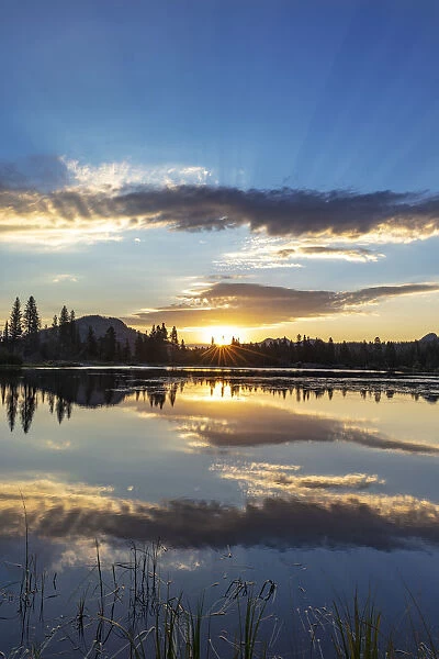 Sunrise clouds reflecting into Sprague Lake in Rocky Mountain National Park, Colorado