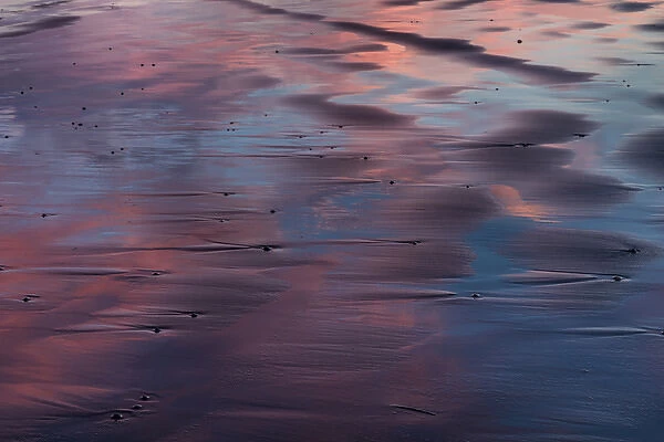 Sunser reflection in the black sand at Vestrahorn Mountain in winter near Hofn, Iceland