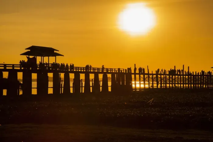 Framed Print : Sunset over the lake near wooden footbridge. U Bein Bridge crossing the Taungthaman Lake