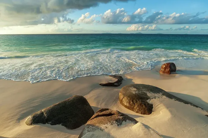 Framed Print : Surf surging towards boulders buried in sand on a tropical beach. Anse Victorin Beach, Fregate Island, Seychelles Framed Print : Surf surging towards boulders buried in sand on a tropical beach. Anse Victorin Beach, Fregate Island, Seychelles