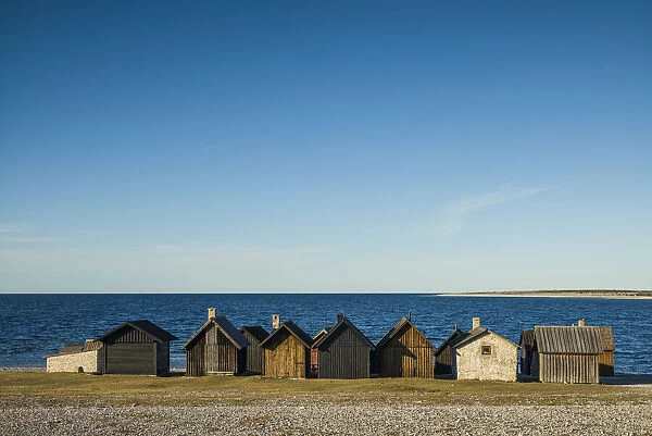 Sweden, Faro Island, Kursviken, coastal farmers fishing shacks, sunset