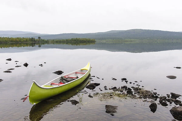 Sweden, Norrbotten, Torne River. Canoe in tranquil waters