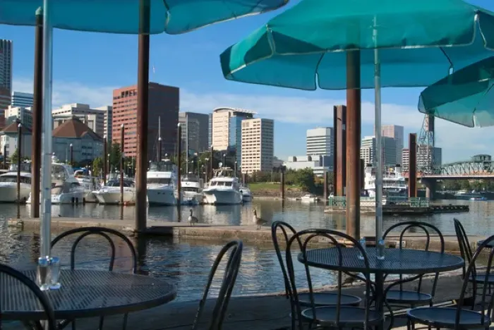 Framed Print : Tables with green umbrellas at a restaurant on the Willamette River, with the Portland Marina