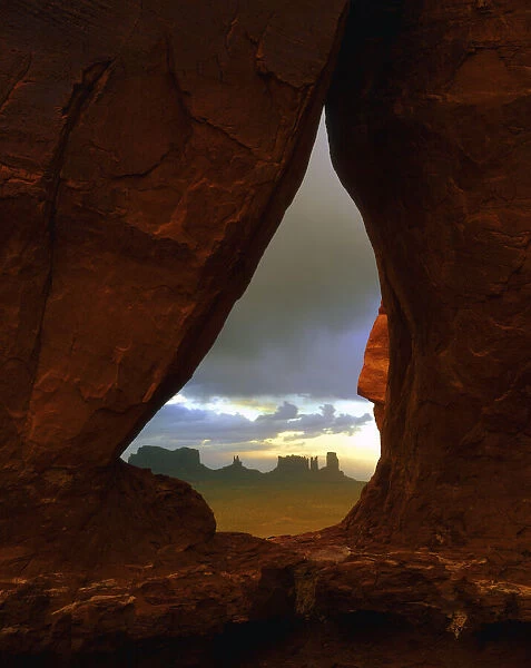 Teardrop arch frames the Monument Valley rock formations on the Utah, Arizona border