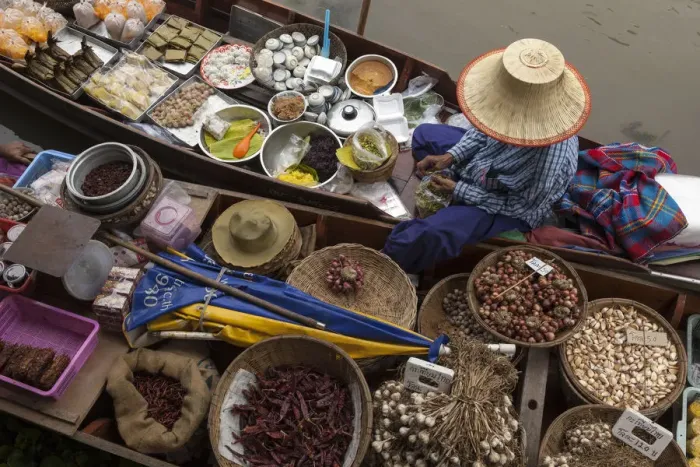 Framed Print : Thailand, Amphawa Floating Market. Woman prepares food for customer in her dugout canoe shop
