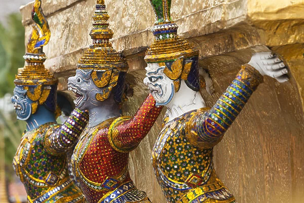 Thailand, Bangkok, Royal Palace. Yaksha (demons) guard one of the golden chedi at