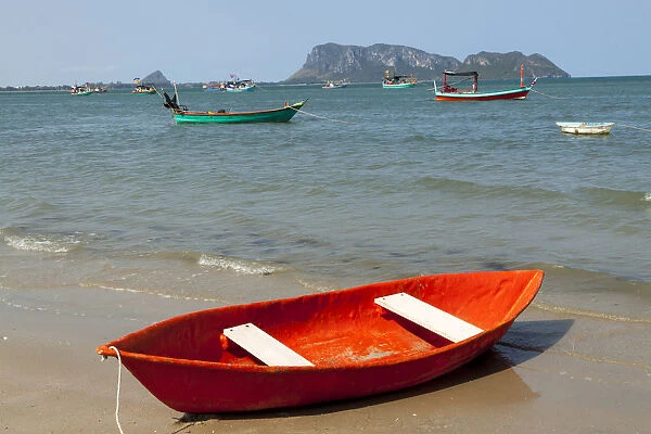 Thailand, Prachuap Khiri Khan. Ao Manao beach. Small colorful rowboats pulled up on the beach