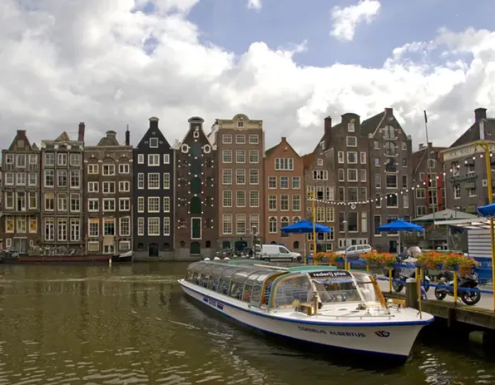Framed Print : A tour boat at Rederij Plas dock on a canal lined with colorful gabled homes
