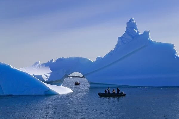 Tourist boat with naturally formed iceberg arch, American Palmer Station, Antarctica