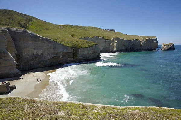 Tourists on beach and cliffs at Tunnel Beach, Dunedin, South Island, New Zealand